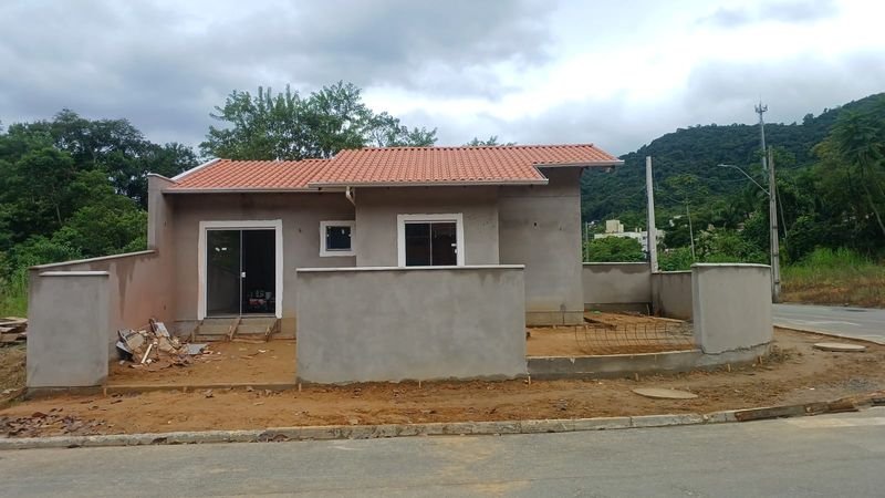 Casa geminada antes da pintura, com muro e paredes no reboco